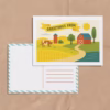 Illustrated DIY postcard for kids featuring a farm landscape. The front includes a “Greetings From” banner with space to write a location. The back shows a traditional postcard layout with an address area and striped border.
